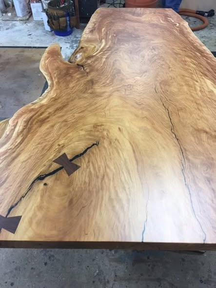 Live-edge Matumi slab table top with dramatic flowing grain, natural checking stabilized by dark walnut bowties, and an ultra-low-sheen clear coat that keeps the surface looking natural.