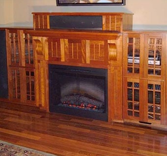 Custom wall unit with surround sound cabinets, German antique glass doors, and curly mahogany panels