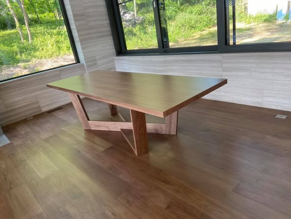 Vertical-grain walnut dining table with a 108-by-39-inch two-inch-thick top on a sculptural client-inspired walnut base, finished in a low-sheen 2K urethane, set in a sunlit modern dining room