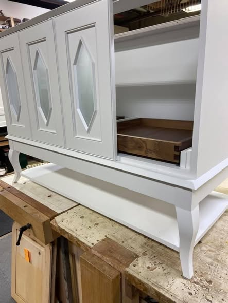 Vanity with one door open showing solid walnut rollout tray inside, double-bead door frame, and diamond panel with frosted glass