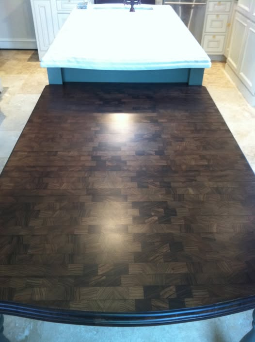 End-grain Zebrano kitchen island extension stained dark with low-sheen clear finish, showing checkerboard end-grain pattern, attached to a painted island with white marble top.